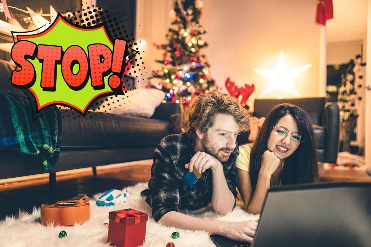 coppia davanti il pc a Natale e scritta stop